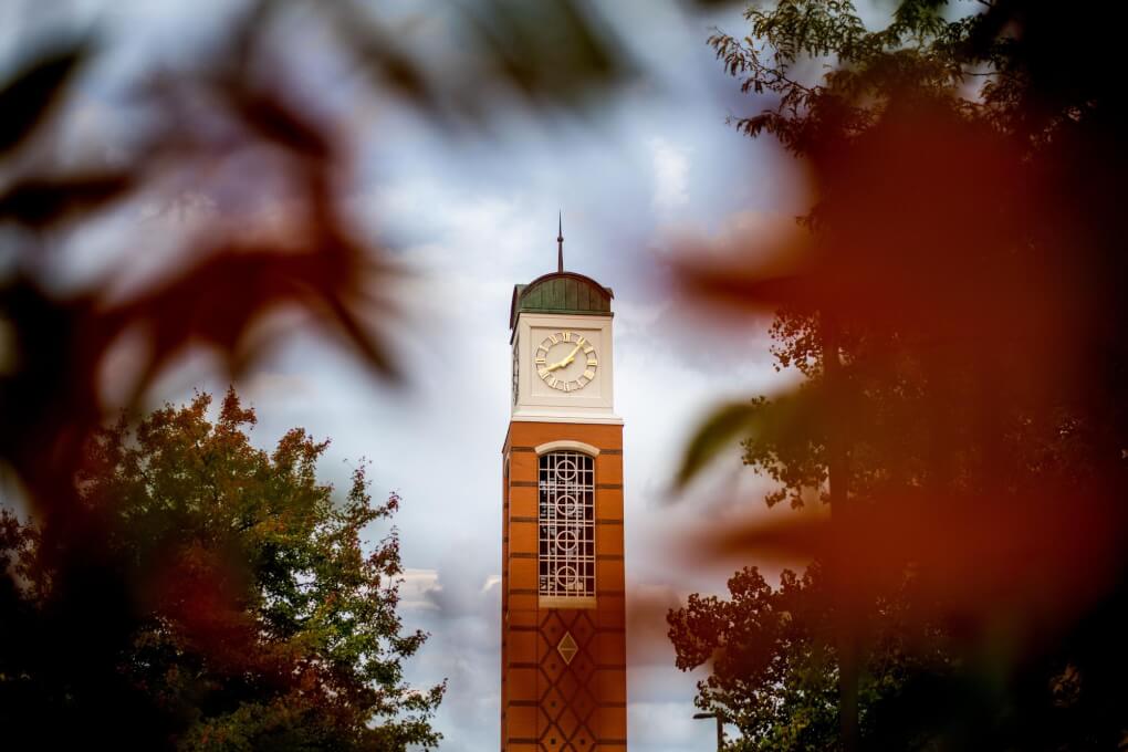 The clocktower is framed with blurred out fall leaves